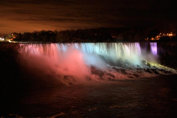 The American falls were lit up in colors, viewed from Niagara Falls on the Canada side.