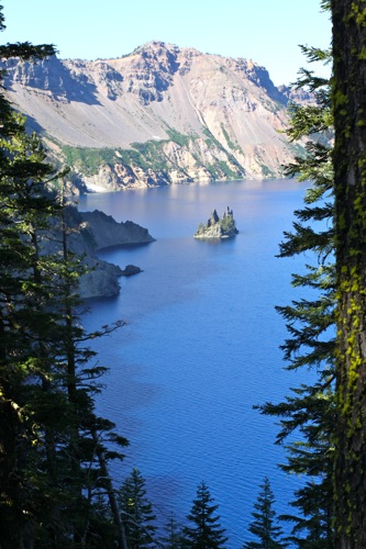 The Phantom Ship peeks through the trees in Crater Lake National Park